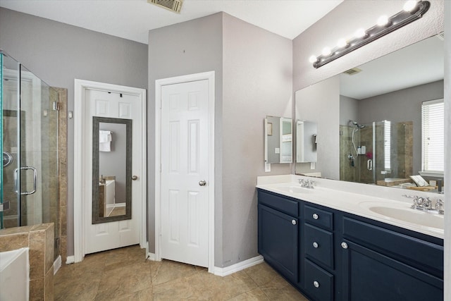 bathroom featuring a stall shower, a sink, baseboards, and double vanity