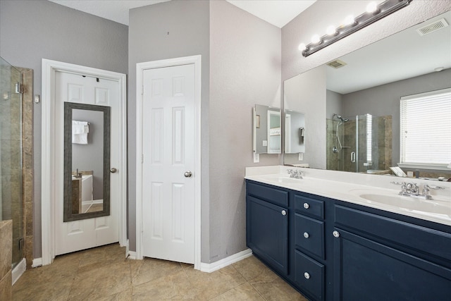 full bathroom with double vanity, a stall shower, visible vents, and a sink