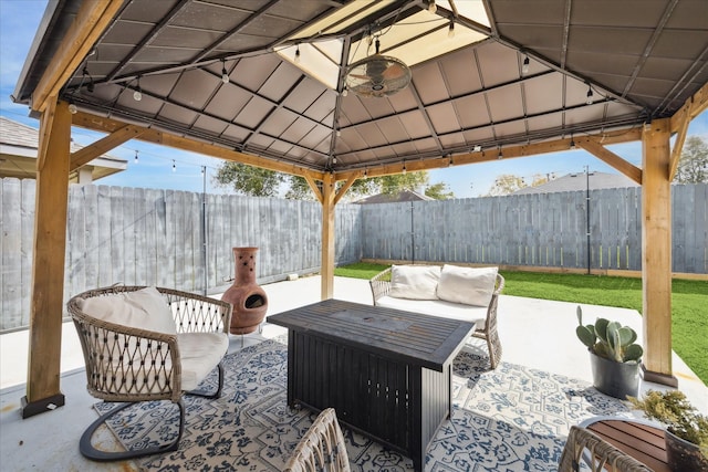 view of patio featuring a fenced backyard, an outdoor living space, and a gazebo