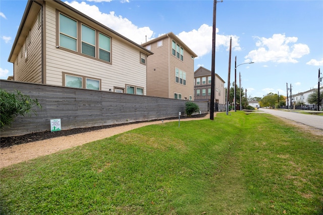 view of property exterior featuring a yard and fence