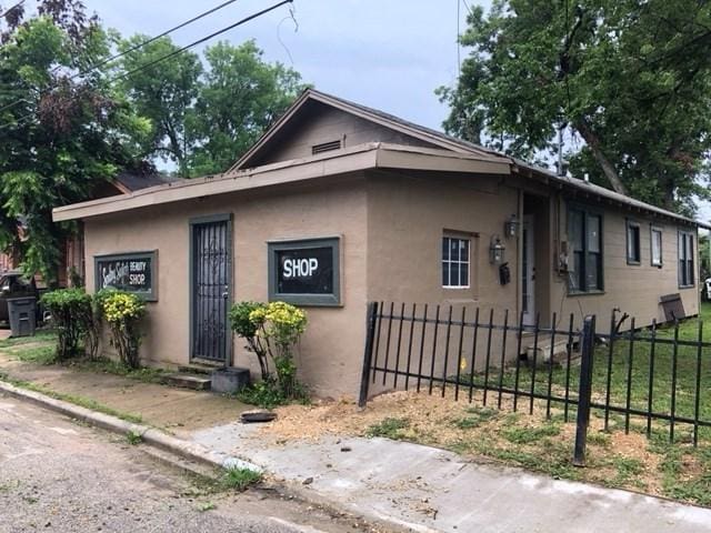 view of front of property with entry steps, a fenced front yard, and stucco siding