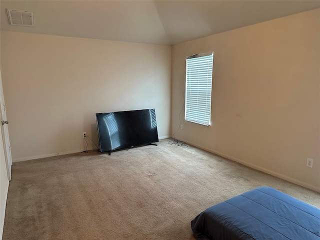 unfurnished bedroom featuring visible vents, carpet flooring, baseboards, and vaulted ceiling