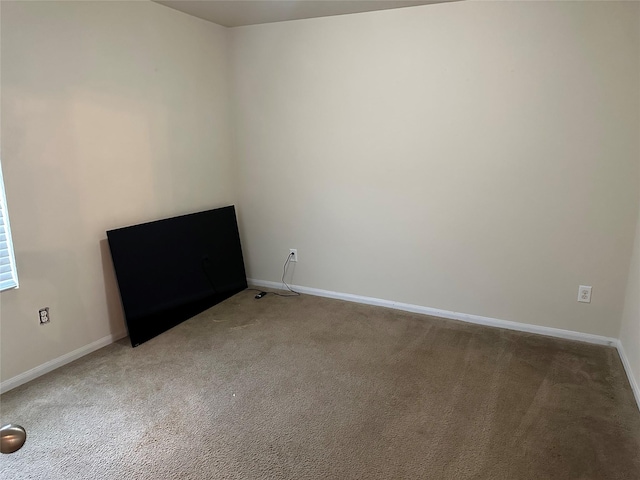 unfurnished room with baseboards and light carpet