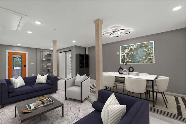 living area featuring recessed lighting, decorative columns, baseboards, and attic access