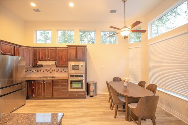 kitchen featuring stainless steel appliances, backsplash, visible vents, and under cabinet range hood