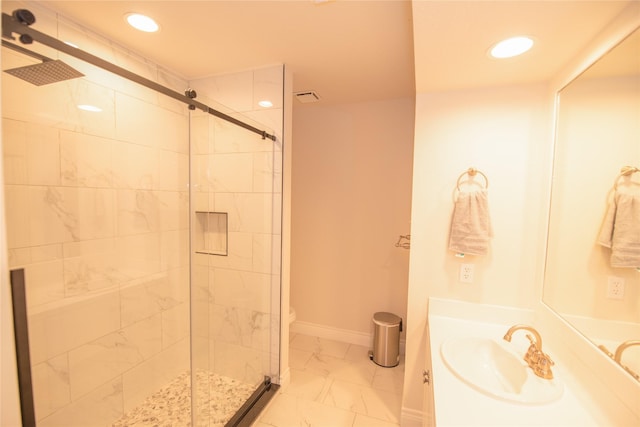 bathroom with marble finish floor, a shower stall, baseboards, and recessed lighting