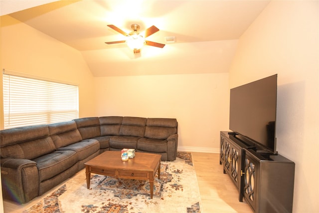 living area featuring visible vents, a ceiling fan, vaulted ceiling, light wood-type flooring, and baseboards