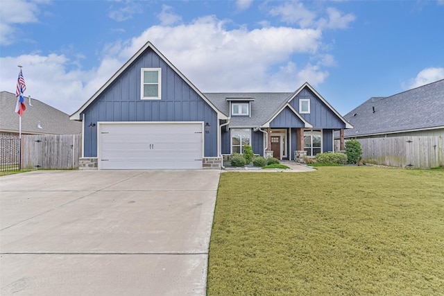 view of front of home with a garage, concrete driveway, fence, board and batten siding, and a front yard