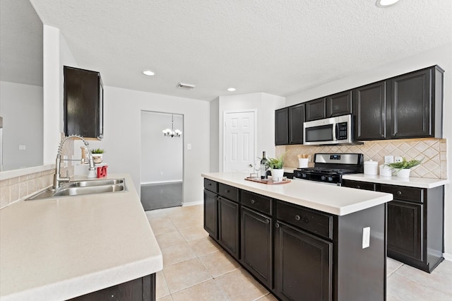 kitchen featuring stainless steel appliances, a sink, visible vents, and decorative backsplash