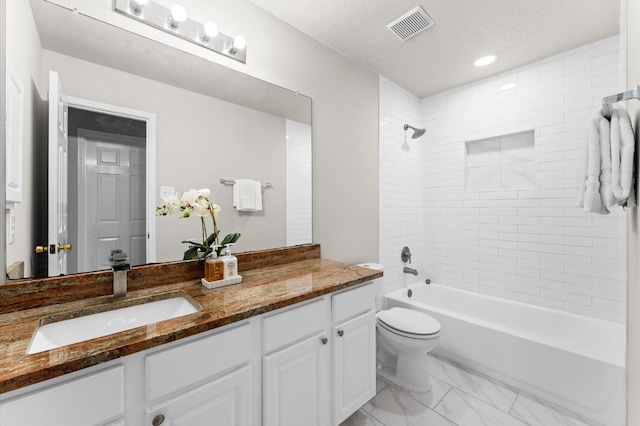 bathroom with bathing tub / shower combination, visible vents, toilet, vanity, and a textured ceiling