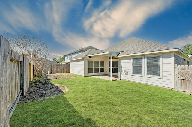 back of house featuring a shingled roof, a patio area, a lawn, and a fenced backyard