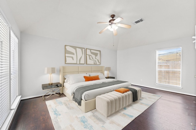 bedroom with baseboards, visible vents, ceiling fan, wood finished floors, and vaulted ceiling