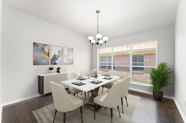 dining space with baseboards, a notable chandelier, and wood finished floors