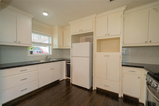 kitchen with a sink, freestanding refrigerator, dark wood-style floors, dark countertops, and stainless steel range with gas stovetop