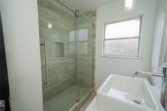 full bath with a shower stall and a sink