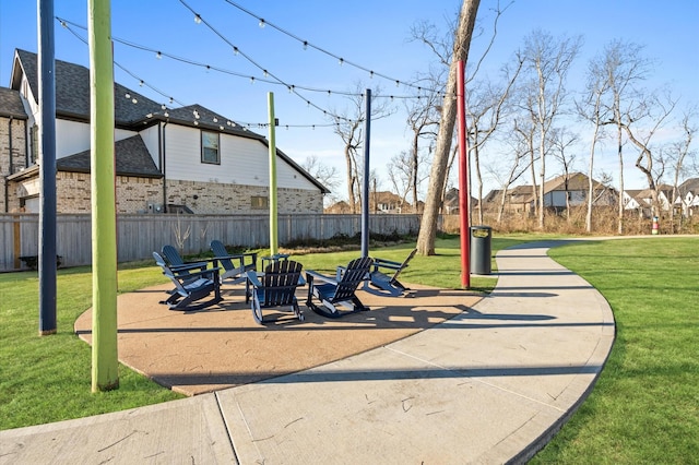 view of home's community with a patio area, fence, and a lawn