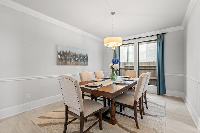 dining room featuring light wood-type flooring, baseboards, and ornamental molding