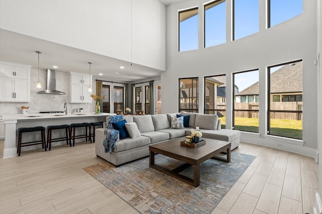 living area with a wealth of natural light, light wood-style flooring, and recessed lighting