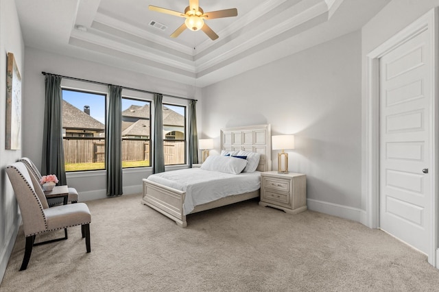 bedroom with light carpet, baseboards, visible vents, and a tray ceiling