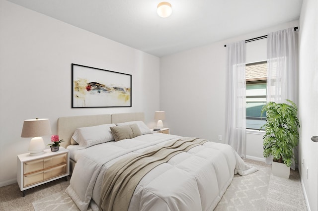 bedroom featuring baseboards and light colored carpet