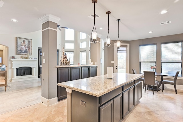 kitchen featuring light stone counters, recessed lighting, a fireplace with raised hearth, and visible vents