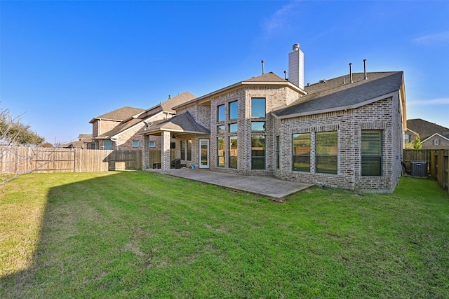 back of property with a lawn, a patio, a fenced backyard, cooling unit, and brick siding