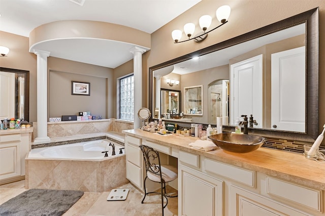 bathroom with a stall shower, decorative columns, a bath, vanity, and backsplash