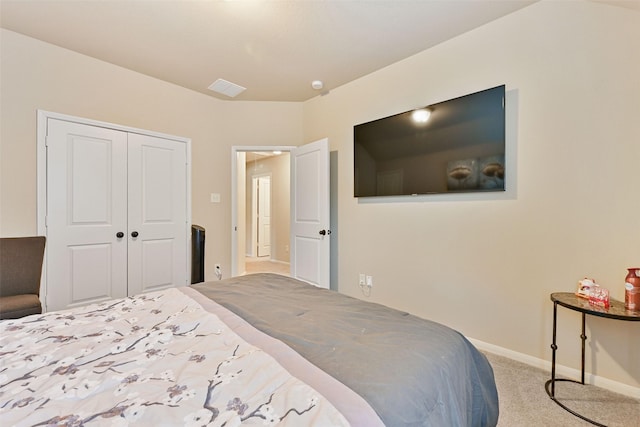 carpeted bedroom featuring a closet, visible vents, and baseboards