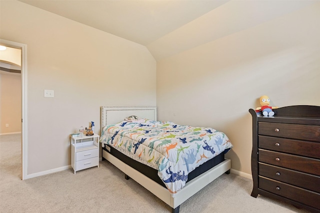 carpeted bedroom featuring lofted ceiling and baseboards