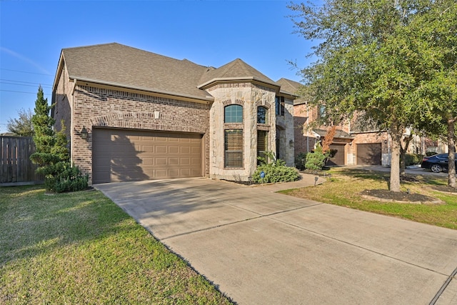 french country style house with brick siding, concrete driveway, stone siding, fence, and a front yard