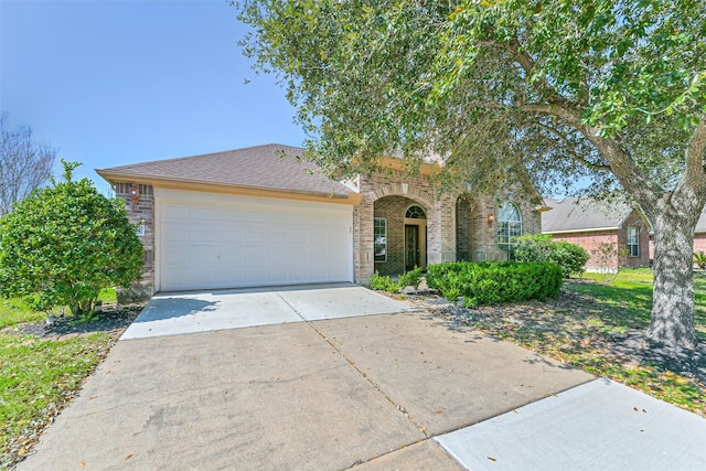 view of front of house featuring concrete driveway, brick siding, and an attached garage