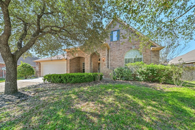 traditional-style home featuring a garage, a front yard, brick siding, and driveway