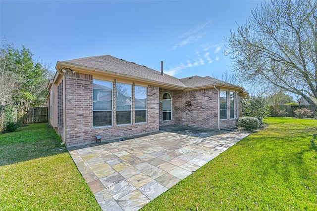 rear view of house with brick siding, a lawn, a patio area, and a fenced backyard