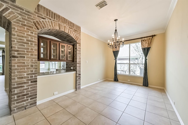 unfurnished dining area featuring light tile patterned floors, ornamental molding, a chandelier, and visible vents