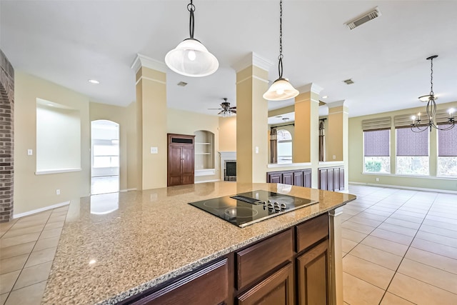 kitchen featuring visible vents, black electric stovetop, open floor plan, and light stone counters