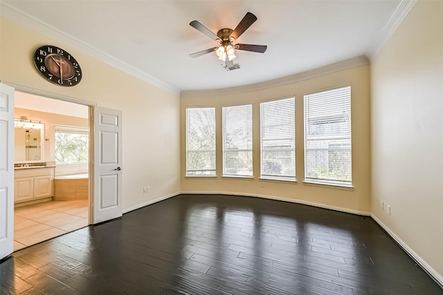 spare room with dark wood-style floors, ornamental molding, a ceiling fan, and baseboards