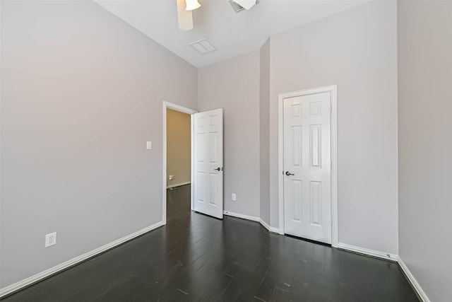 unfurnished room featuring ceiling fan, dark wood-style flooring, and baseboards