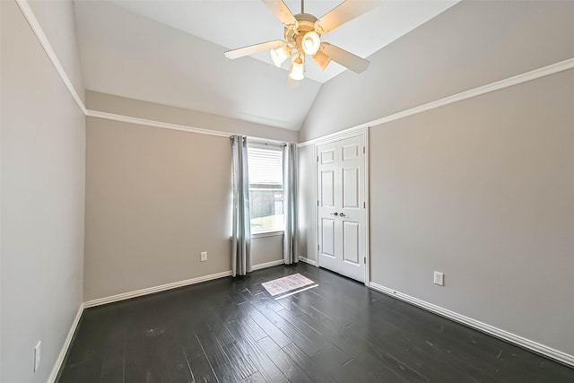 empty room with vaulted ceiling, ceiling fan, dark wood-style flooring, and baseboards