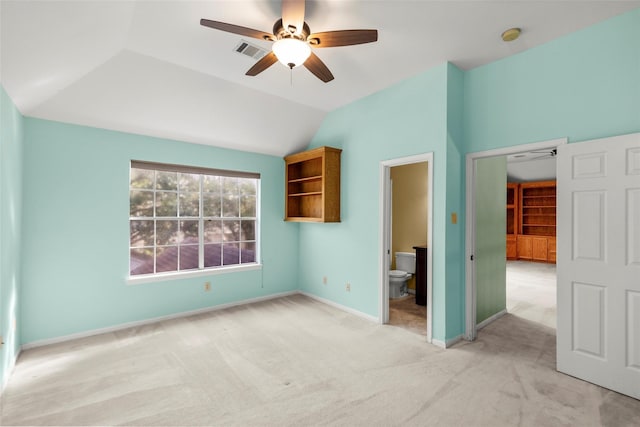 unfurnished bedroom with light colored carpet, visible vents, lofted ceiling, and baseboards