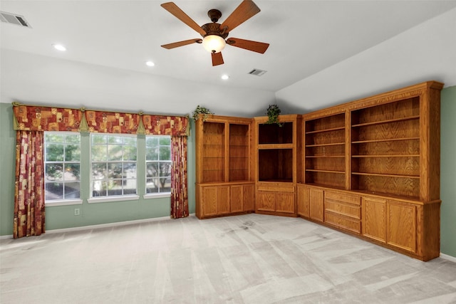 empty room featuring lofted ceiling, baseboards, visible vents, and light colored carpet