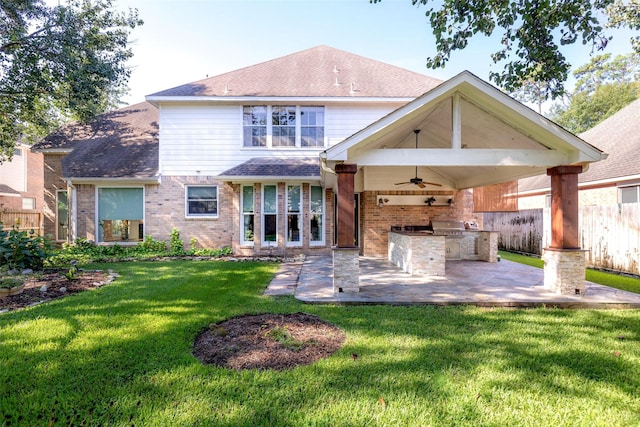 rear view of property with exterior kitchen, brick siding, fence, and a patio