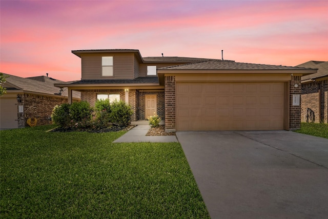 view of front of house with a front yard, concrete driveway, brick siding, and an attached garage