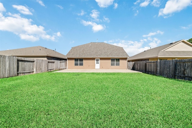 back of house with a shingled roof, a fenced backyard, a patio, and a lawn