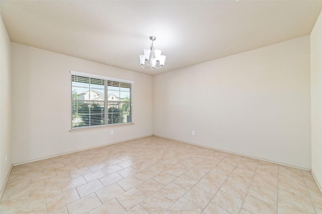 empty room featuring an inviting chandelier and light tile patterned floors