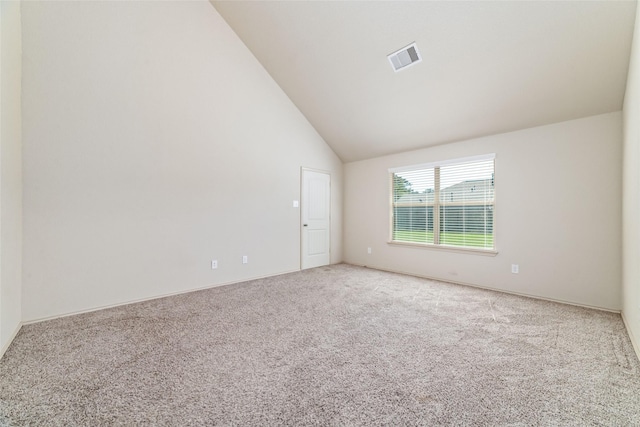 carpeted spare room featuring visible vents and high vaulted ceiling