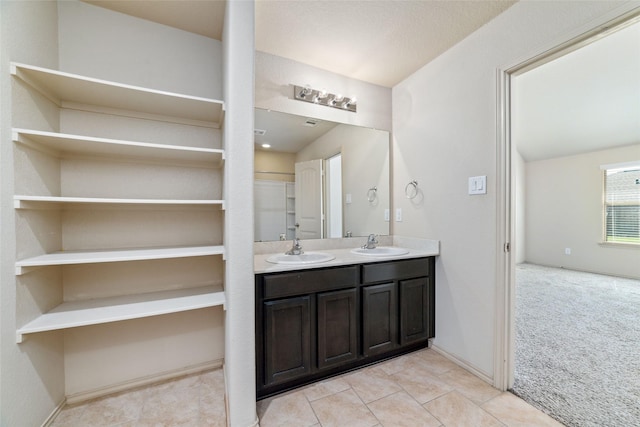 full bathroom with double vanity, a sink, and tile patterned floors