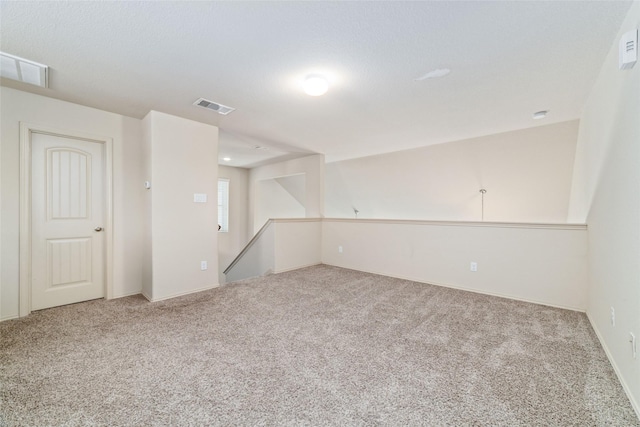 carpeted spare room featuring visible vents