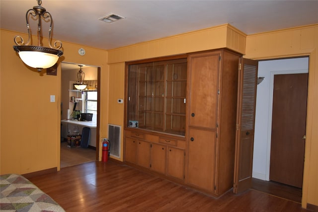 foyer featuring visible vents, wooden walls, and wood finished floors