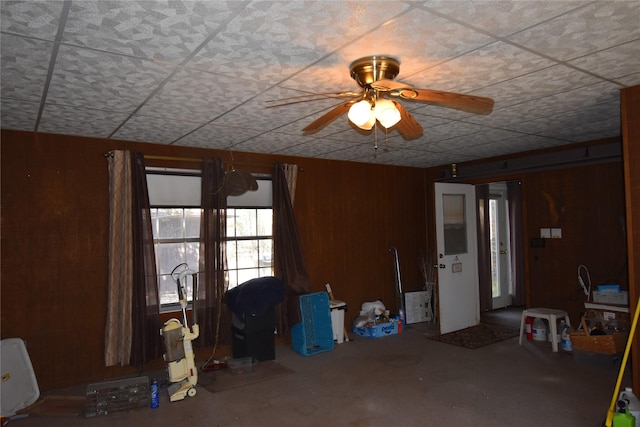 empty room with wood walls and a ceiling fan