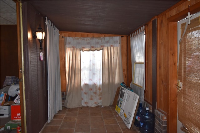 misc room featuring stone finish floor and wooden walls